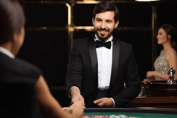 A woman in a luxurious green gown next to an ornate roulette wheel, capturing the upscale casino mood of 334OK.